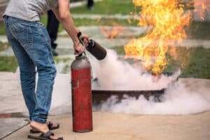 Demonstration of using a fire extinguisher to put out flames during fire safety training