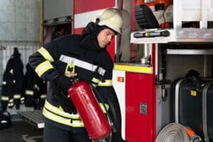 Firefighter showing fire safety equipment during an educational station visit for children