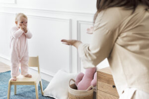 Babysitter leading indoor games with a toddler at home