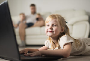 Child learning online safety skills while using a laptop at home